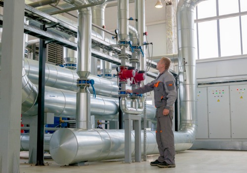 A technician in a boiler room with IL Commercial Boilers