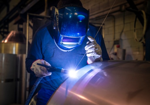 A technician welding a boiler during an Emergency Boiler Repair in IL