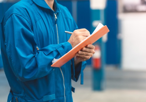Cropped View of a Mechanic Consulting a Checklist During an Industrial Boiler Repair in Illinois